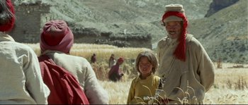 Movie still from “Himalaya” (1999), directed by Eric Valli – An older man and a young girl in a field; Medium shot, Over the shoulder angle