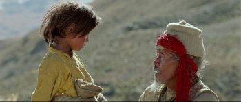 Movie still from “Himalaya” (1999), directed by Eric Valli – An older man and a young girl in a field; Close Up shot, Over the shoulder angle