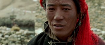 Movie still from “Himalaya” (1999), directed by Eric Valli – A person wearing a red hat; Close Up shot, High angle