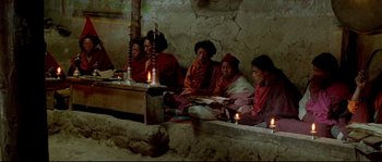 Movie still from “Himalaya” (1999), directed by Eric Valli – A group of people sitting around a table with candles on it; Wide shot, High angle