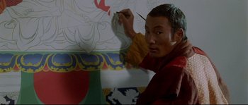 Movie still from “Himalaya” (1999), directed by Eric Valli – A man painting a picture on a wall; Close Up shot, High angle