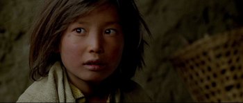 Movie still from “Himalaya” (1999), directed by Eric Valli – A young girl is looking into the camera; Close Up shot, High angle