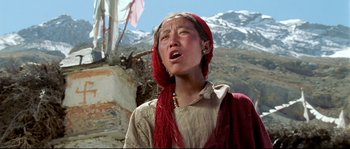 Movie still from “Himalaya” (1999), directed by Eric Valli – A woman with a red scarf on her head; Close Up shot, Low angle