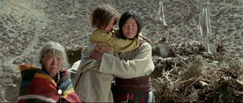 Movie still from “Himalaya” (1999), directed by Eric Valli – A woman and a young girl are hugging in a field; Medium shot, High angle