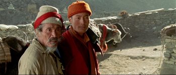 Movie still from “Himalaya” (1999), directed by Eric Valli – Two men standing in front of a herd of cattle; Close Up shot, High angle