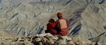 Movie still from “Himalaya” (1999), directed by Eric Valli – A man and woman sitting on top of a mountain; Wide shot, High angle