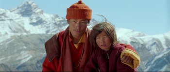 Movie still from “Himalaya” (1999), directed by Eric Valli – A man standing next to a little girl in front of a mountain range; Close Up shot, Low angle