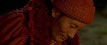 Movie still from “Himalaya” (1999), directed by Eric Valli – A person wearing a hat and a red scarf; Extreme Close Up shot, High angle