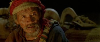 Movie still from “Himalaya” (1999), directed by Eric Valli – An old man with a beard and a red hat; Close Up shot, High angle