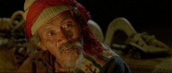 Movie still from “Himalaya” (1999), directed by Eric Valli – An old man with a beard and a red hat; Close Up shot, High angle
