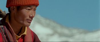 Movie still from “Himalaya” (1999), directed by Eric Valli – A man wearing a hat and a red sweater; Close Up shot, Low angle
