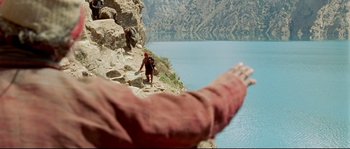 Movie still from “Himalaya” (1999), directed by Eric Valli – A man walking up a steep hill on a mountain; Extreme Wide shot, High angle