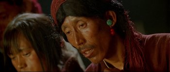 Movie still from “Himalaya” (1999), directed by Eric Valli – A man wearing a red hat and a green hat; Close Up shot, High angle