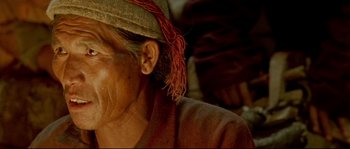 Movie still from “Himalaya” (1999), directed by Eric Valli – An older woman with a hat on her head; Close Up shot, High angle
