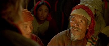 Movie still from “Himalaya” (1999), directed by Eric Valli – An old man and two young women in a dark room; Close Up shot, High angle