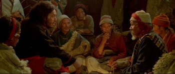 Movie still from “Himalaya” (1999), directed by Eric Valli – A group of people sitting on the ground; Medium shot, High angle