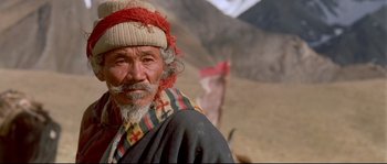 Movie still from “Himalaya” (1999), directed by Eric Valli – An older man with a beard and a hat; Close Up shot, Low angle