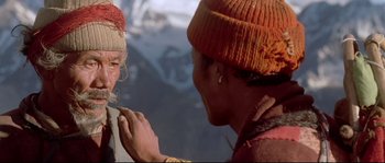Movie still from “Himalaya” (1999), directed by Eric Valli – A woman wearing a hat is looking into a mirror; Close Up shot, Over the shoulder angle