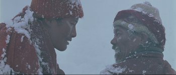 Movie still from “Himalaya” (1999), directed by Eric Valli – Two people in the snow looking at each other; Close Up shot, Low angle