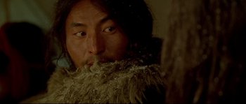 Movie still from “Himalaya” (1999), directed by Eric Valli – A man with a long beard is looking at the camera; Close Up shot, Over the shoulder angle