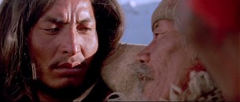 Movie still from “Himalaya” (1999), directed by Eric Valli – An older man and a younger man are looking at one another; Close Up shot, Over the shoulder angle