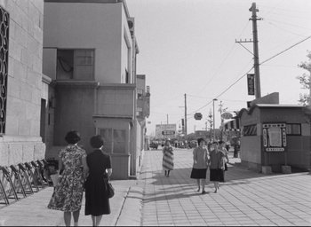 Movie still from “Hiroshima Mon Amour” (1959), directed by Alain Resnais – A group of women walking down a sidewalk; Extreme Wide shot, Low angle