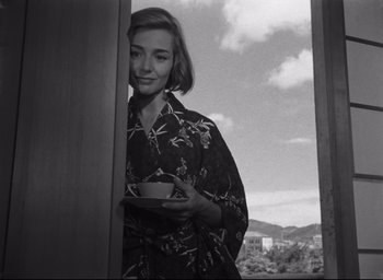 Movie still from “Hiroshima Mon Amour” (1959), directed by Alain Resnais – A woman holding a bowl of food in her hands; Medium shot, Low angle