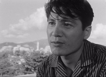 Movie still from “Hiroshima Mon Amour” (1959), directed by Alain Resnais – Black and white photograph of a young man in a striped shirt; Close Up shot, Low angle