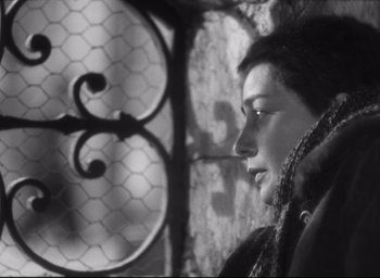 Movie still from “Hiroshima Mon Amour” (1959), directed by Alain Resnais – A black - and - white photo of a woman looking out a window; Close Up shot, High angle
