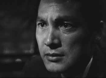 Movie still from “Hiroshima Mon Amour” (1959), directed by Alain Resnais – Black and white photograph of a man's face in a car; Close Up shot, Low angle