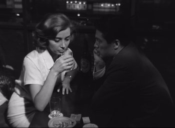 Movie still from “Hiroshima Mon Amour” (1959), directed by Alain Resnais – A man and a woman sitting at a table; Medium shot, High angle