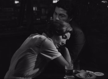 Movie still from “Hiroshima Mon Amour” (1959), directed by Alain Resnais – A man and a woman sitting at a dinner table; Medium shot, Low angle