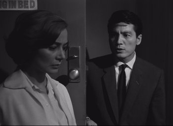 Movie still from “Hiroshima Mon Amour” (1959), directed by Alain Resnais – A man and a woman standing next to each other in front of an elevator; Medium shot, Low angle