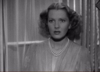 Movie still from “History Is Made at Night” (1937), directed by Frank Borzage – An old black and white photo of a woman wearing a pearl necklace; Close Up shot, High angle