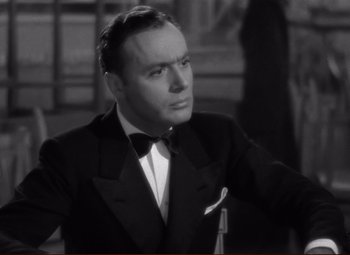 Movie still from “History Is Made at Night” (1937), directed by Frank Borzage – A man in a suit and bow tie looking to his left; Close Up shot, Low angle