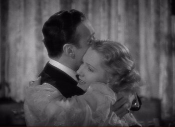 Movie still from “History Is Made at Night” (1937), directed by Frank Borzage – A man and a woman embracing each other in front of a curtain; Close Up shot, High angle