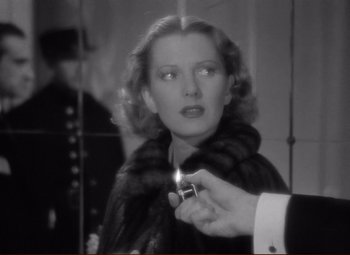 Movie still from “History Is Made at Night” (1937), directed by Frank Borzage – A black and white photo of a woman holding a cigarette; Close Up shot, Over the shoulder angle