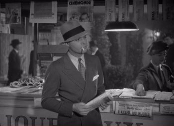 Movie still from “History Is Made at Night” (1937), directed by Frank Borzage – A black and white photo of a man smoking a cigarette; Medium shot, High angle