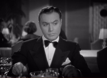 Movie still from “History Is Made at Night” (1937), directed by Frank Borzage – A man in a tuxedo sitting at a dinner table; Close Up shot, High angle