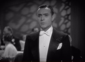 Movie still from “History Is Made at Night” (1937), directed by Frank Borzage – A man in a tuxedo standing in front of a wall; Close Up shot, Low angle