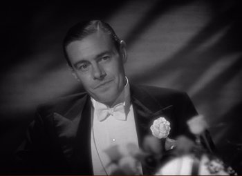 Movie still from “History Is Made at Night” (1937), directed by Frank Borzage – A black and white photo of a man in a tuxedo; Close Up shot, Low angle