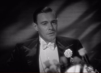 Movie still from “History Is Made at Night” (1937), directed by Frank Borzage – A black and white photo of a man in a tuxedo; Close Up shot, High angle