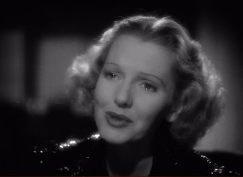 Movie still from “History Is Made at Night” (1937), directed by Frank Borzage – An old photo of a woman in a sequined jacket; Close Up shot, Over the shoulder angle