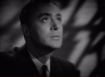 Movie still from “History Is Made at Night” (1937), directed by Frank Borzage – Black and white photograph of a man in a suit looking up; Close Up shot, Low angle