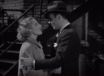Movie still from “History Is Made at Night” (1937), directed by Frank Borzage – A man and a woman embracing each other in front of a staircase; Medium shot, High angle