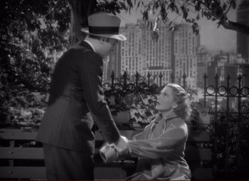 Movie still from “History Is Made at Night” (1937), directed by Frank Borzage – A man and a woman holding hands on a park bench; Medium shot, High angle