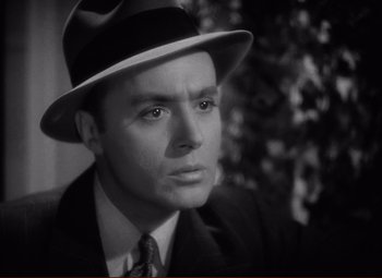 Movie still from “History Is Made at Night” (1937), directed by Frank Borzage – A man wearing a suit and a hat; Close Up shot, High angle