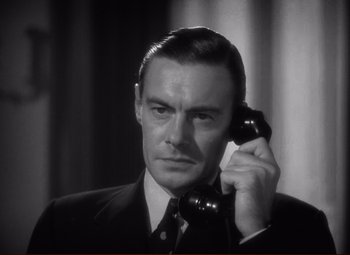 Movie still from “History Is Made at Night” (1937), directed by Frank Borzage – A black and white photo of a man talking on a phone; Close Up shot, High angle