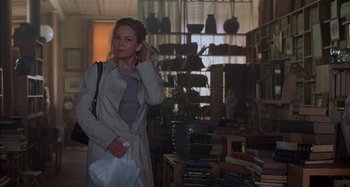 Movie still from “Unfaithful” (2002), directed by Adrian Lyne – A woman standing in front of a bunch of books; Medium shot, Over the shoulder angle