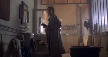 Movie still from “Unfaithful” (2002), directed by Adrian Lyne – A woman standing in front of a window in a room; Wide shot, Low angle